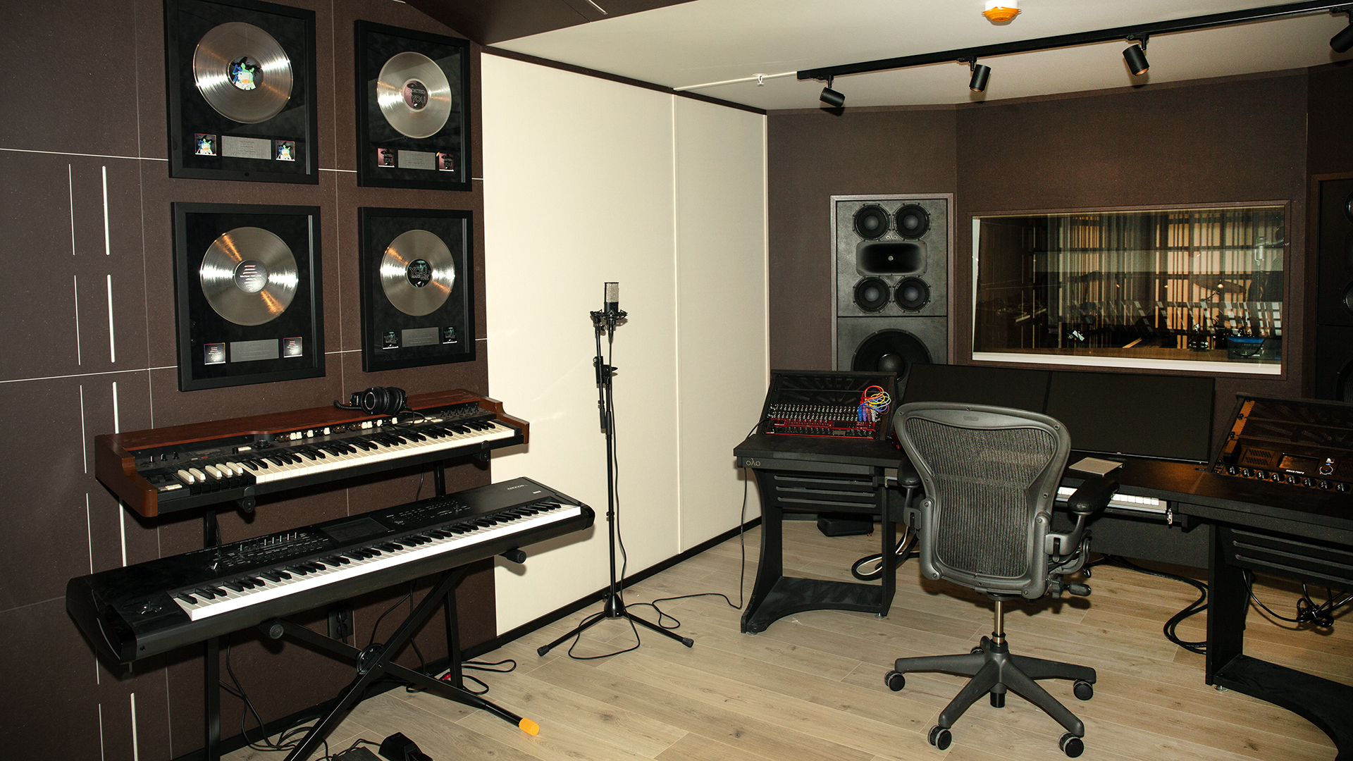 En av studiorummen med keyboards, ljudmixerbord och mickar, foto.